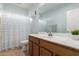 Bathroom featuring a wood vanity, shower-tub combo with curtain and large mirror at 17423 W Yavapai St, Goodyear, AZ 85338