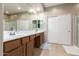 Well-lit bathroom with a long vanity, closet, and separate shower at 17423 W Yavapai St, Goodyear, AZ 85338