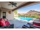 Covered patio with a comfortable seating area overlooking the pool and backyard at 17423 W Yavapai St, Goodyear, AZ 85338