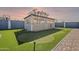 Backyard view of the enclosed entertainment area with putting green and manicured lawn at 1881 S 223Rd Dr, Buckeye, AZ 85326