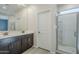 Bright bathroom featuring double sink vanity, glass enclosed shower, and tile flooring at 1881 S 223Rd Dr, Buckeye, AZ 85326