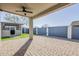 Covered patio with a ceiling fan, brick pavers, and backyard views at 1881 S 223Rd Dr, Buckeye, AZ 85326