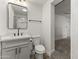 Bathroom featuring a white toilet, white cabinets, black fixtures, and a gray countertop at 1908 N 47Th St, Phoenix, AZ 85008