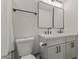 Well-lit bathroom with double sinks, square mirrors, modern faucet fixtures, and gray cabinets at 1908 N 47Th St, Phoenix, AZ 85008