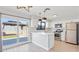 Modern kitchen with white cabinets, stainless steel appliances, pendant lights, and sliding doors to the backyard gazebo at 2110 W Pampa Ave, Mesa, AZ 85202