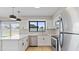 Well-lit kitchen featuring stainless steel appliances, sleek countertops, modern light fixtures, and a view to the backyard at 2110 W Pampa Ave, Mesa, AZ 85202