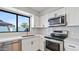 Modern kitchen with white cabinets, stainless steel appliances, and a large window at 2110 W Pampa Ave, Mesa, AZ 85202