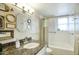 Bathroom featuring vanity with granite countertop, decorative mirrors, and tiled bathtub with shower at 2201 N Central Ave # 11A, Phoenix, AZ 85004