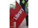 Signage directs visitors toward the library using a big red arrow and white, bold lettering at 2201 N Central Ave # 11A, Phoenix, AZ 85004