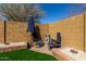 A cozy backyard space features brick landscaping, a rock border, and a seating area with a patio umbrella at 22624 S 224Th Pl, Queen Creek, AZ 85142