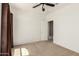 This bedroom features neutral walls and carpet, a ceiling fan, and a view into an adjoining room at 22624 S 224Th Pl, Queen Creek, AZ 85142