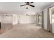 Expansive living room with neutral carpet, ceiling fans, access to the backyard and large windows at 22624 S 224Th Pl, Queen Creek, AZ 85142