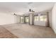 Open-concept living area with neutral carpet, multiple ceiling fans, and access to the backyard at 22624 S 224Th Pl, Queen Creek, AZ 85142