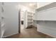 Spacious walk-in closet with built-in shelving, rod, and a neutral carpet leading to the bathroom at 22624 S 224Th Pl, Queen Creek, AZ 85142