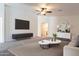 Well-lit living room featuring a large flat screen TV, a fan, and modern decorations at 23276 W Cocopah St, Buckeye, AZ 85326