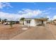 Charming white home with a long covered carport and low maintenance gravel yard at 241 S 54Th St, Mesa, AZ 85206