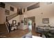 Spacious living room featuring high ceilings, tile flooring, and staircase with dark wood and iron railings at 2454 E Stacey Rd, Gilbert, AZ 85298