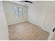 Bright bedroom featuring wood-look flooring, a ceiling fan, and a window allowing natural light at 25912 N Langley Dr, Peoria, AZ 85383