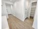 Hallway with wood-look floors leads to an open pantry for convenient storage and organization at 25912 N Langley Dr, Peoria, AZ 85383