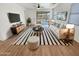 Bright living room featuring a striped rug, modern furniture, and sliding glass doors to the backyard at 25912 N Langley Dr, Peoria, AZ 85383