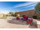 Backyard with a decorative stone patio, mature landscaping, and comfortable seating area at 25983 W Escuda Dr, Buckeye, AZ 85396