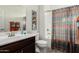 Well-lit bathroom with decorative flower art, a dark wooden vanity and a shower-tub combo at 25983 W Escuda Dr, Buckeye, AZ 85396