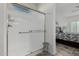 Clean bathroom featuring a tiled walk-in shower with a glass door and seating at 25983 W Escuda Dr, Buckeye, AZ 85396