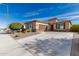 Beige single-Gathering home with a large driveway, a desert landscaped front yard, and a two car garage at 25983 W Escuda Dr, Buckeye, AZ 85396