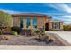 Tan single-Gathering home with rock landscaping and desert plants out front with a small tree on the left side at 25983 W Escuda Dr, Buckeye, AZ 85396