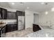 Kitchen featuring a center island, stainless steel appliances, dark wood cabinets, granite countertops, and tile flooring at 25983 W Escuda Dr, Buckeye, AZ 85396