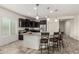 Kitchen island with granite countertop and dark wood cabinets and barstool seating with stainless steel appliances at 25983 W Escuda Dr, Buckeye, AZ 85396