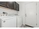 Functional laundry room with washer, dryer, and dark wood cabinetry at 25983 W Escuda Dr, Buckeye, AZ 85396