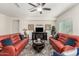 Bright living room with ceiling fan, fireplace, sofas, rug, and large windows offering plenty of natural light at 25983 W Escuda Dr, Buckeye, AZ 85396