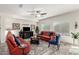 Welcoming living room features a ceiling fan, fireplace, comfortable sofas, rug, and windows at 25983 W Escuda Dr, Buckeye, AZ 85396