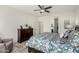 Serene main bedroom showcasing tiled floors, dark wood dresser, and ceiling fan at 25983 W Escuda Dr, Buckeye, AZ 85396