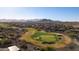 High angle aerial view of a golf course community showcasing lush greens, homes, and beautiful desert mountain views at 27138 W Escuda Dr, Buckeye, AZ 85396