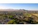 An aerial view of the community featuring a pool, golf course, tennis courts, and mountain views at 27138 W Escuda Dr, Buckeye, AZ 85396