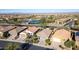 An aerial view showcasing houses and a golf course near a pond at 27138 W Escuda Dr, Buckeye, AZ 85396