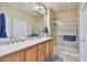 Bright bathroom with double sinks, a large mirror, and a glass-enclosed shower at 27138 W Escuda Dr, Buckeye, AZ 85396