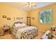 Inviting bedroom featuring a colorful quilt, ceiling fan, and window with natural light at 27138 W Escuda Dr, Buckeye, AZ 85396