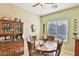 Cozy dining room featuring a round wood table, hutch with collectibles, and a window with natural light at 27138 W Escuda Dr, Buckeye, AZ 85396