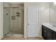 Bathroom featuring a glass shower and dark cabinets with a white countertop at 29219 W Clarendon Ave, Buckeye, AZ 85396