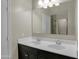 Bright bathroom featuring double sinks with modern fixtures and black cabinets at 29219 W Clarendon Ave, Buckeye, AZ 85396