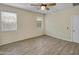 Well-lit bedroom with wood-look tile flooring, ceiling fan and bright windows at 29219 W Clarendon Ave, Buckeye, AZ 85396