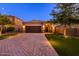 Beautiful single-Gathering home with a two-car garage, brick driveway, and manicured front yard landscaping at 29219 W Clarendon Ave, Buckeye, AZ 85396