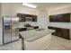 Bright kitchen with stainless steel appliances, a granite island, and dark wood cabinets at 29219 W Clarendon Ave, Buckeye, AZ 85396