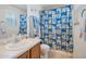 Bright bathroom with a large mirror, neutral countertop, and shower with fun character-themed curtain at 3049 E Santa Rosa Dr, Gilbert, AZ 85234