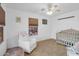 Bright bedroom featuring a crib, rocking chair, neutral carpet, and a window bringing in natural light at 3049 E Santa Rosa Dr, Gilbert, AZ 85234