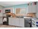 Functional kitchen with a window, white cabinets, and black appliances creating a modern, clean look at 3049 E Santa Rosa Dr, Gilbert, AZ 85234