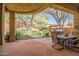 An outdoor patio features a stone dining table and built in barbeque station in a desert landscape at 3108 W Ravina Ln, Anthem, AZ 85086